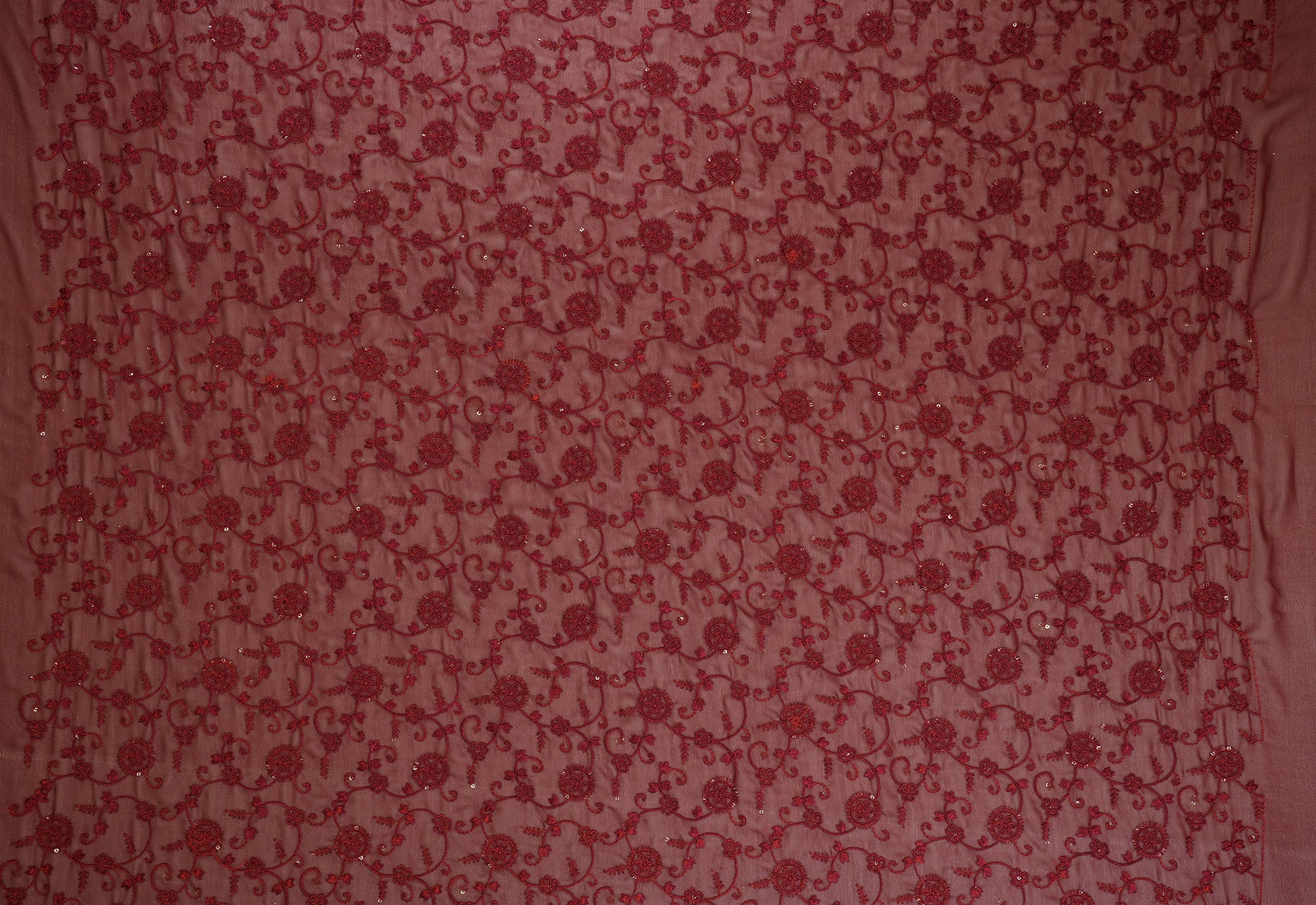 Thread work with golden sequins creating floral overall pattern on maroon georgette fabric