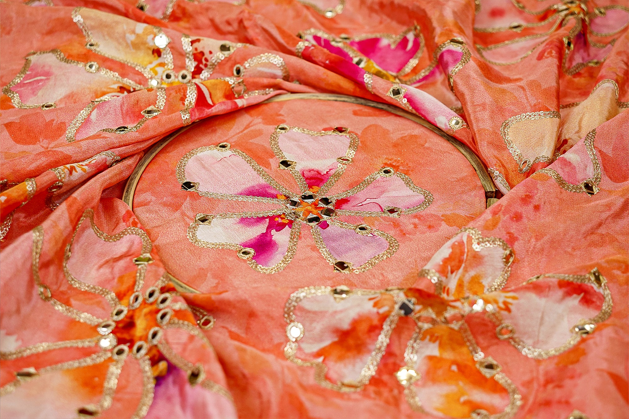 Peach floral crepe fabric with zari, faux mirror, and sequin embellishments for elegant designs - Paras Gallery Fabrics