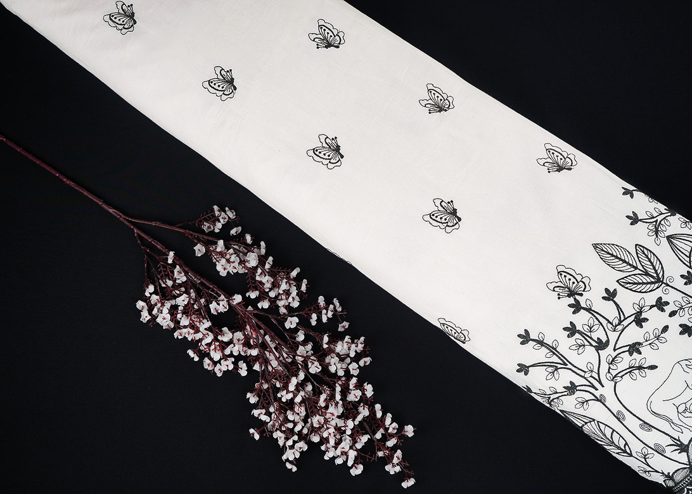 White Dyeable Cambric Cotton Fabric With All Over Butterfly Motif Of Black Thread Work And Scalloped Border 22782