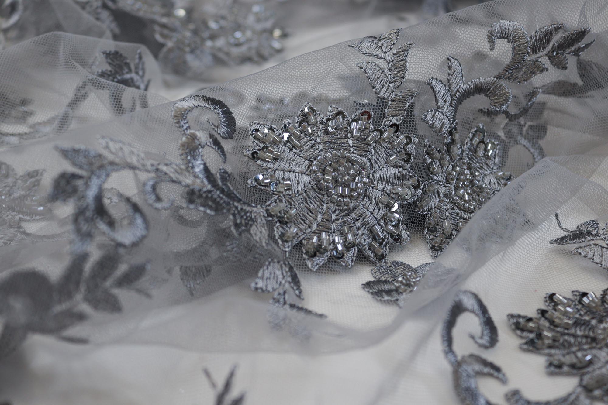 Floral grey net fabric with intricate threadwork, sequins, beads, and decorative border – Paras Gallery Fabrics