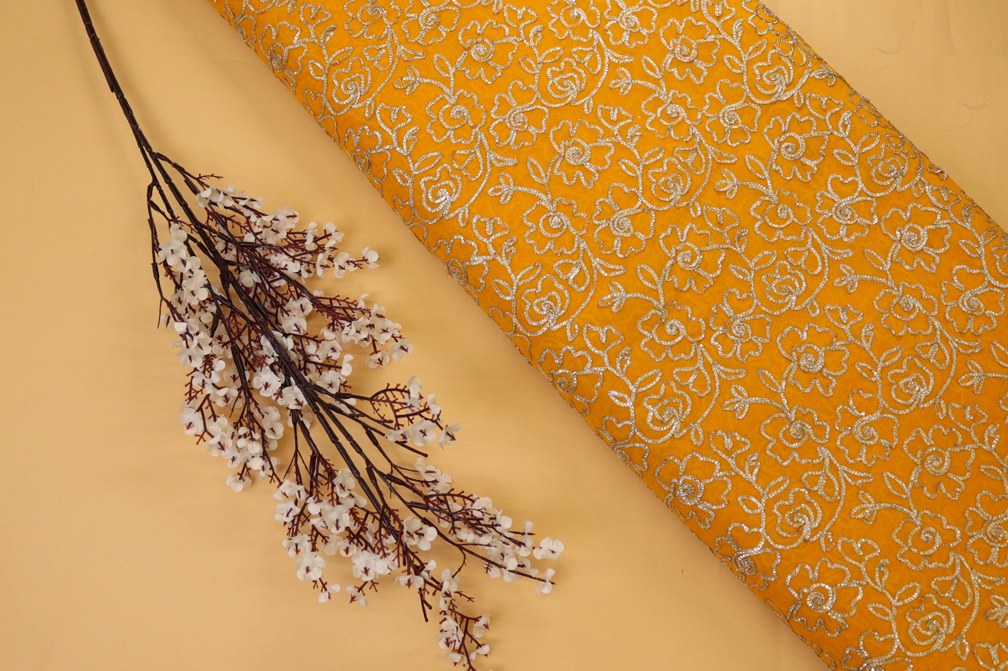 Mustard yellow georgette fabric with gotta patti work creating floral allover pattern