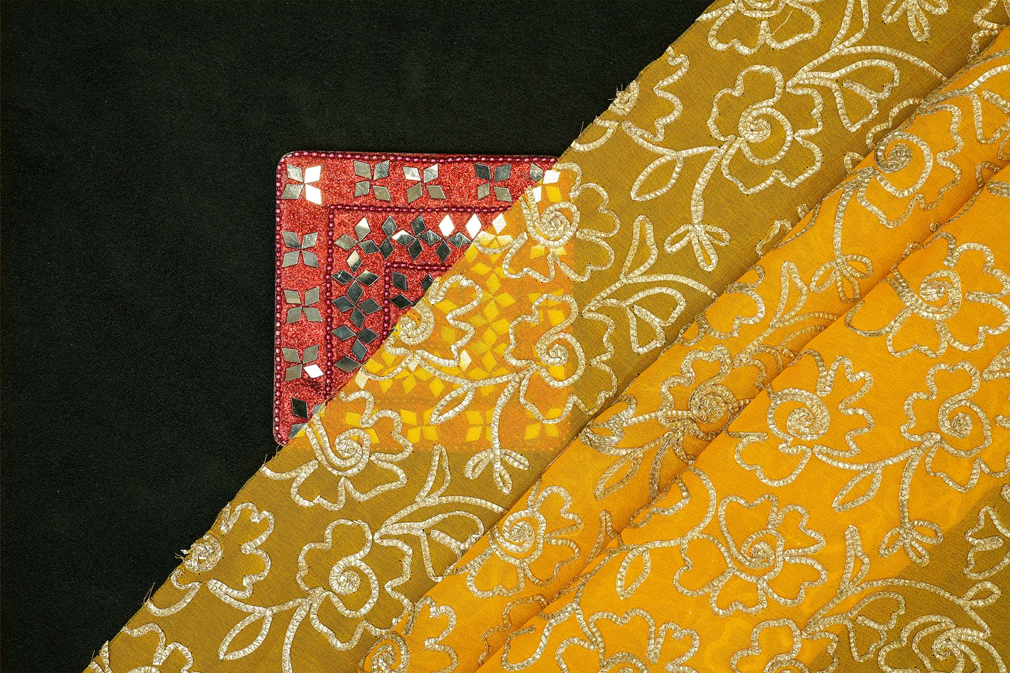 Mustard yellow georgette fabric with gotta patti work creating floral allover pattern