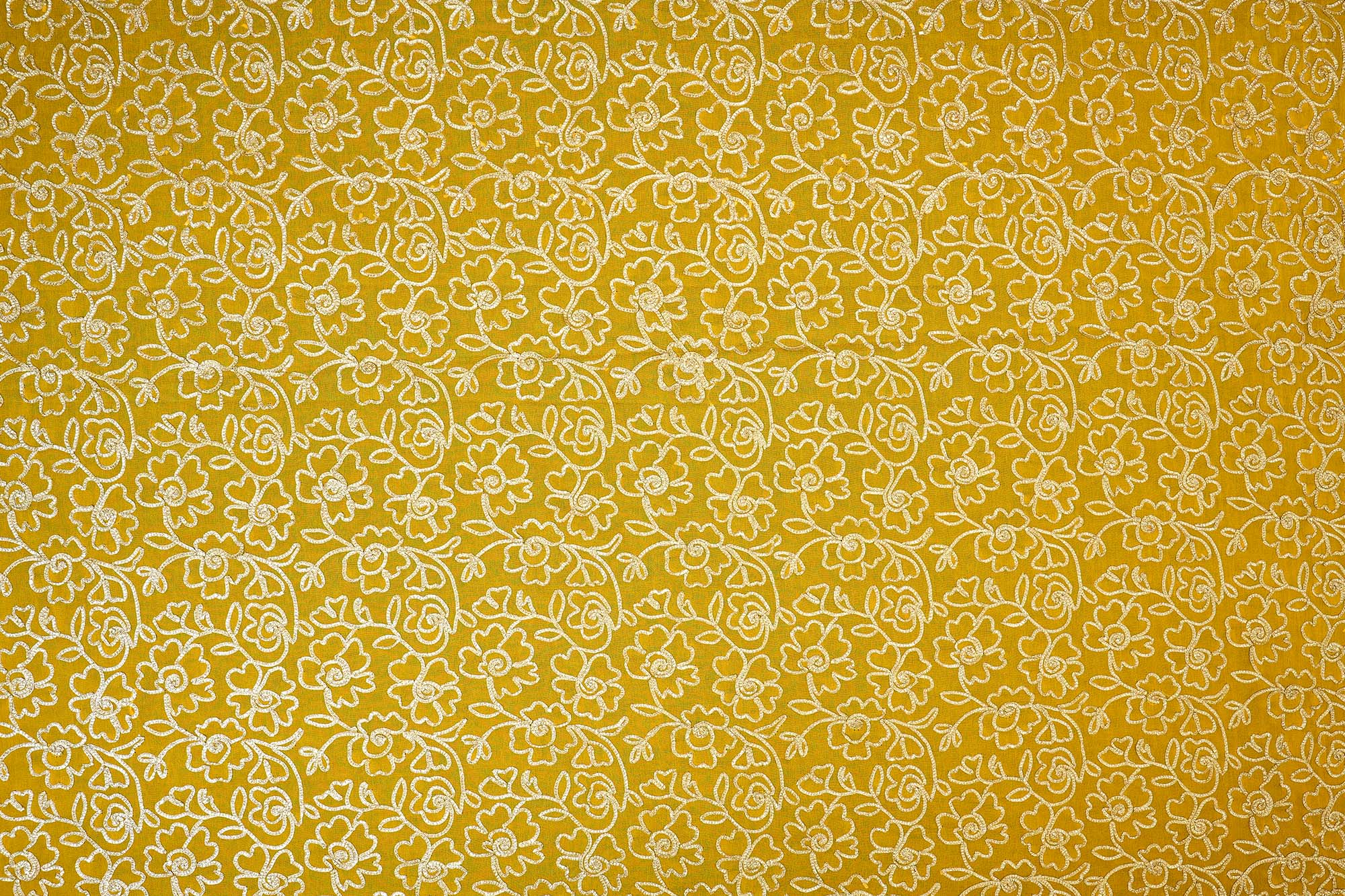 Mustard yellow georgette fabric with gotta patti work creating floral allover pattern