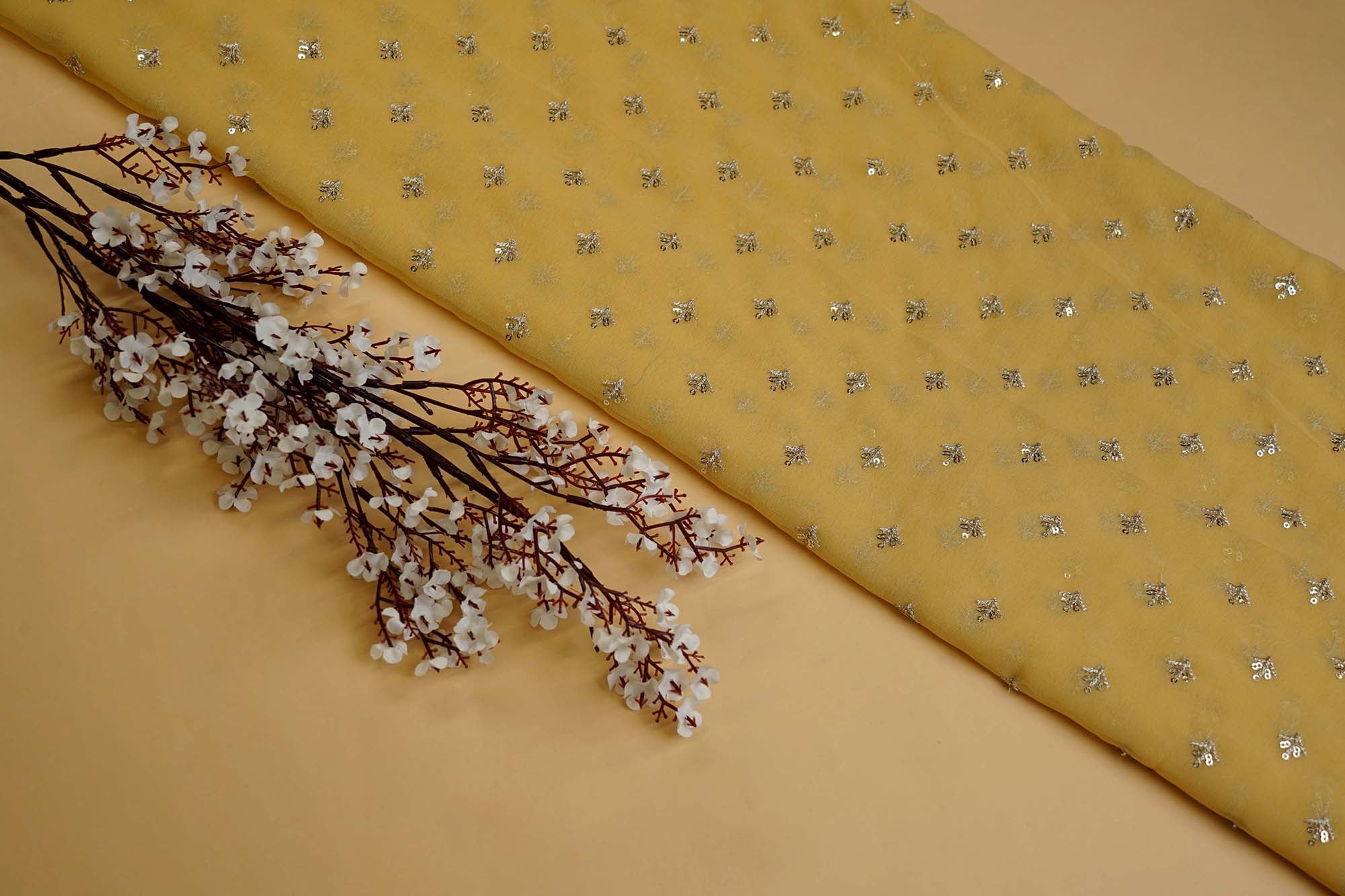 Yellow georgette fabric with golden sequins with golden zari small motif creating allover pattern