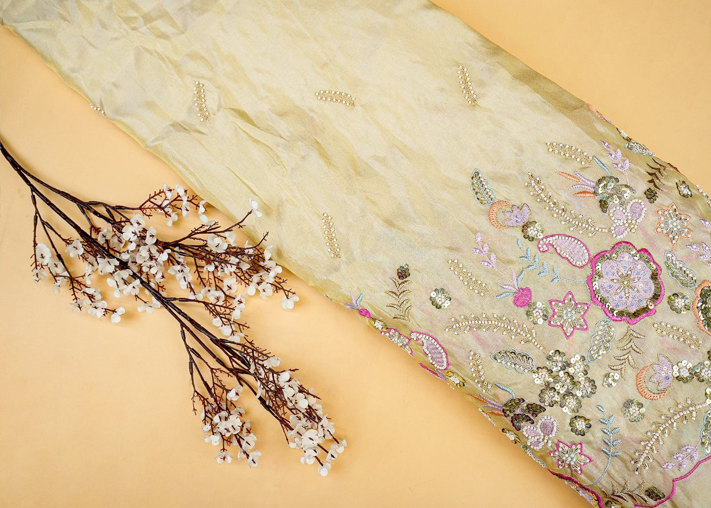 A vibrant yellow silk scarf adorned with a floral and leafy pattern