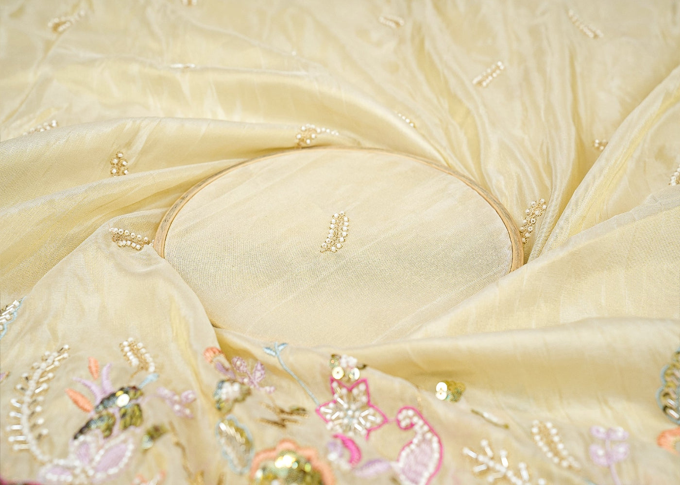 A round embroidered fabric featuring a delicate flower design