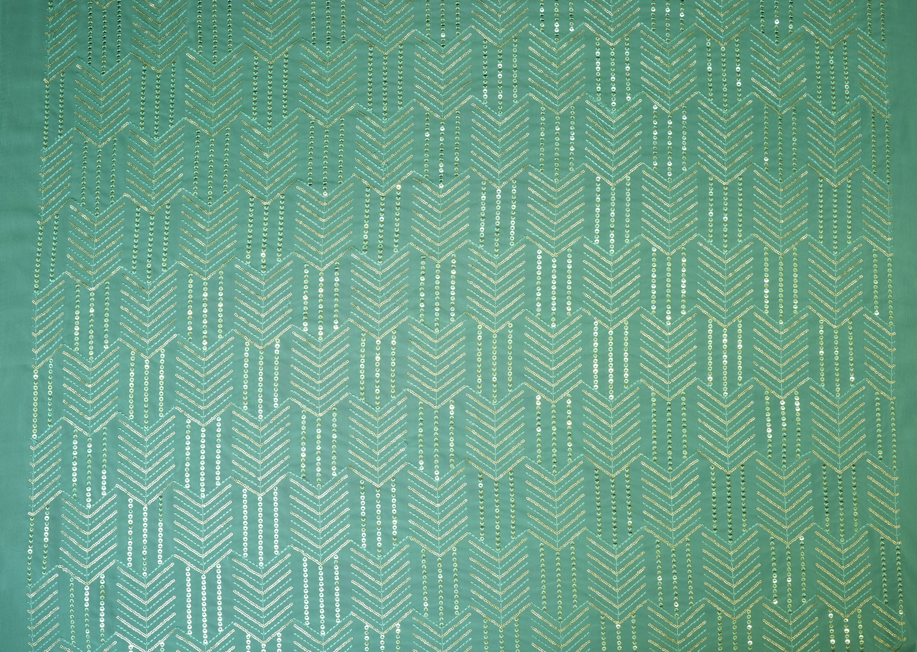 Thread work with golden sequins creating abstract pattern on teal georgette fabric