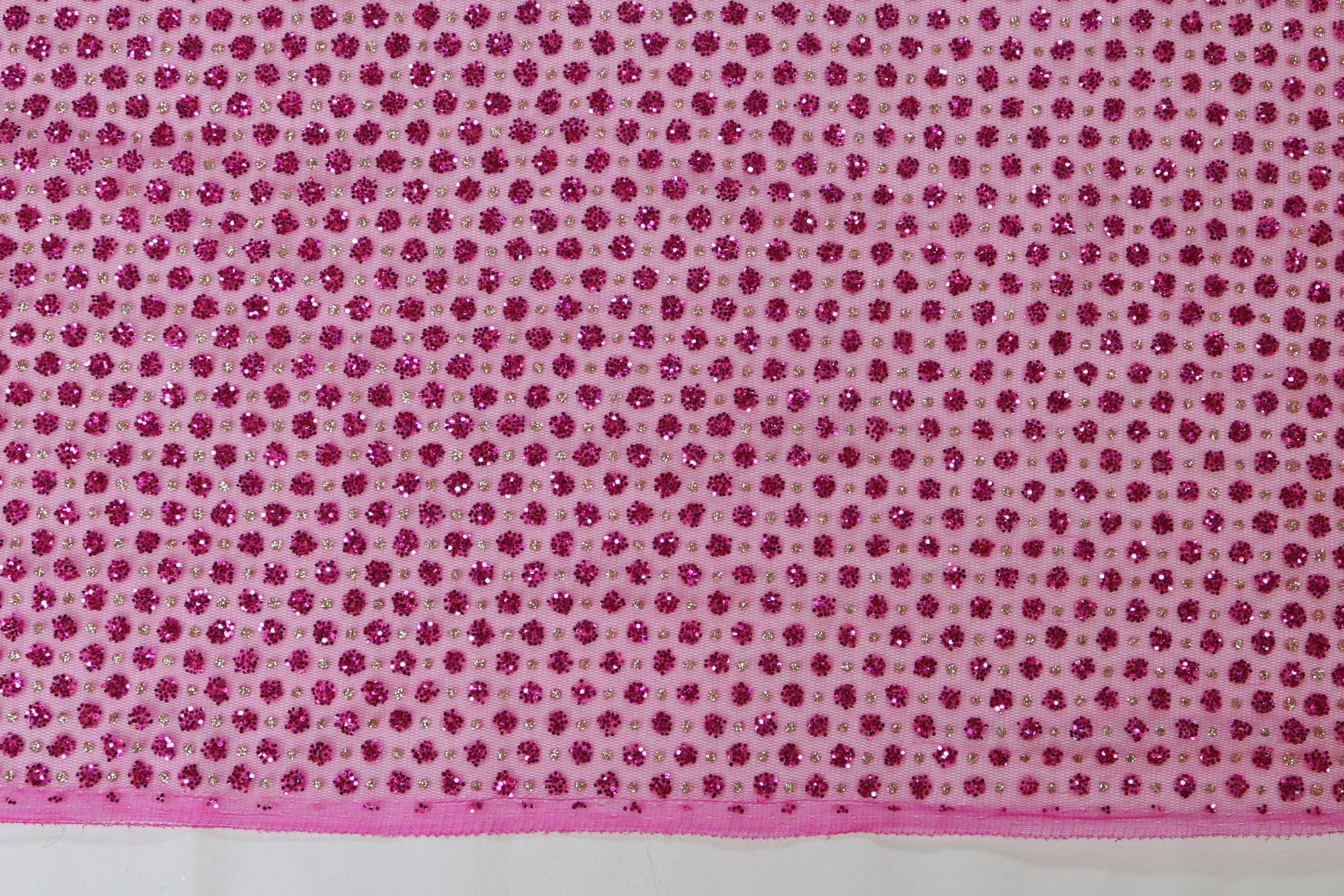 Hot pink net with glitter overall creating abstract pattern