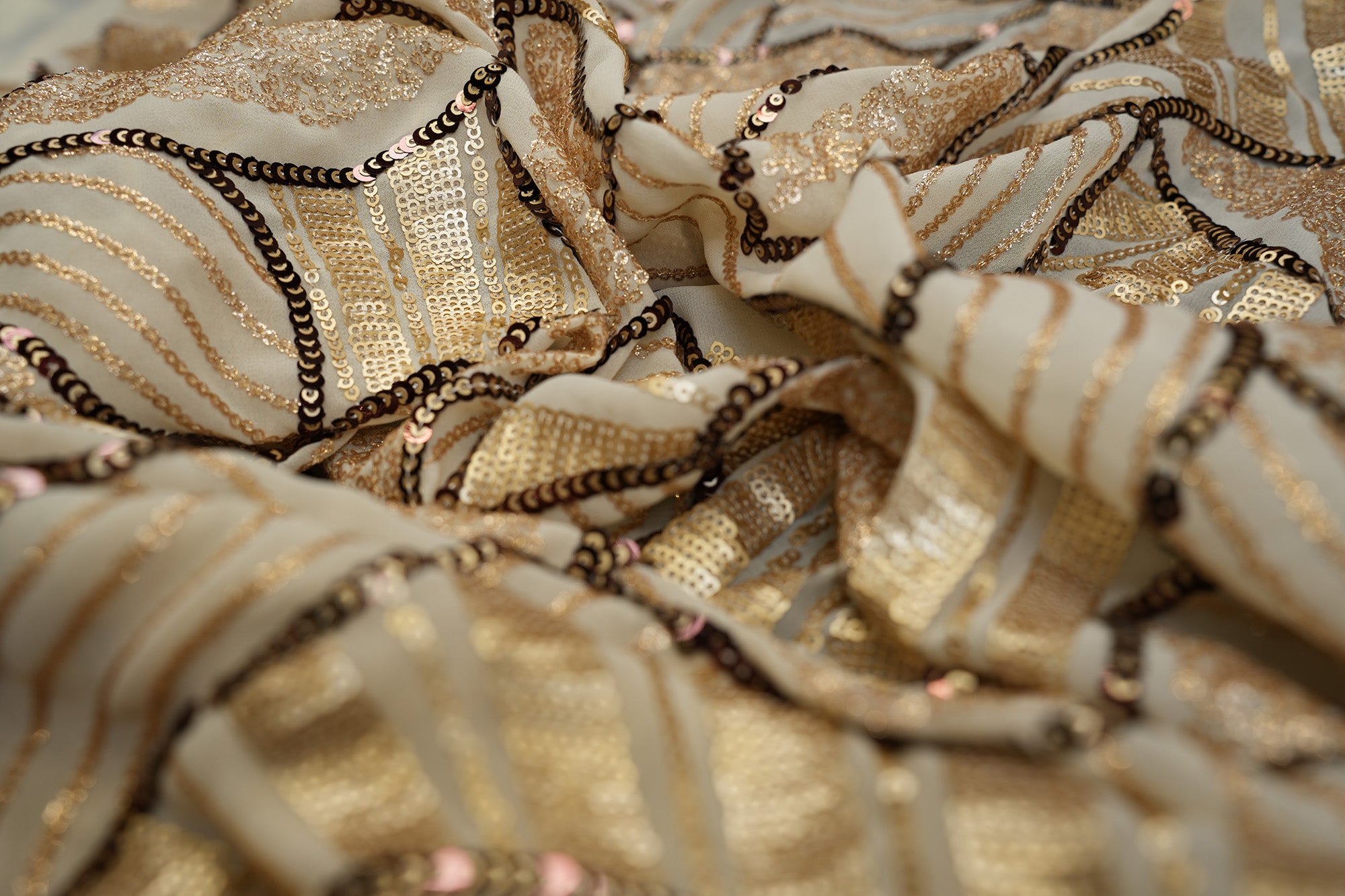 Beige glitter and antique sequins work creating abstract all over pattern on beige georgette fabric