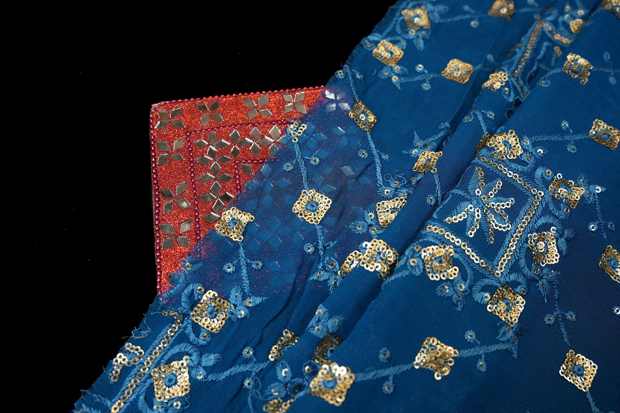 Blue georgette fabric with thread with golden sequins creating geometric allover pattern