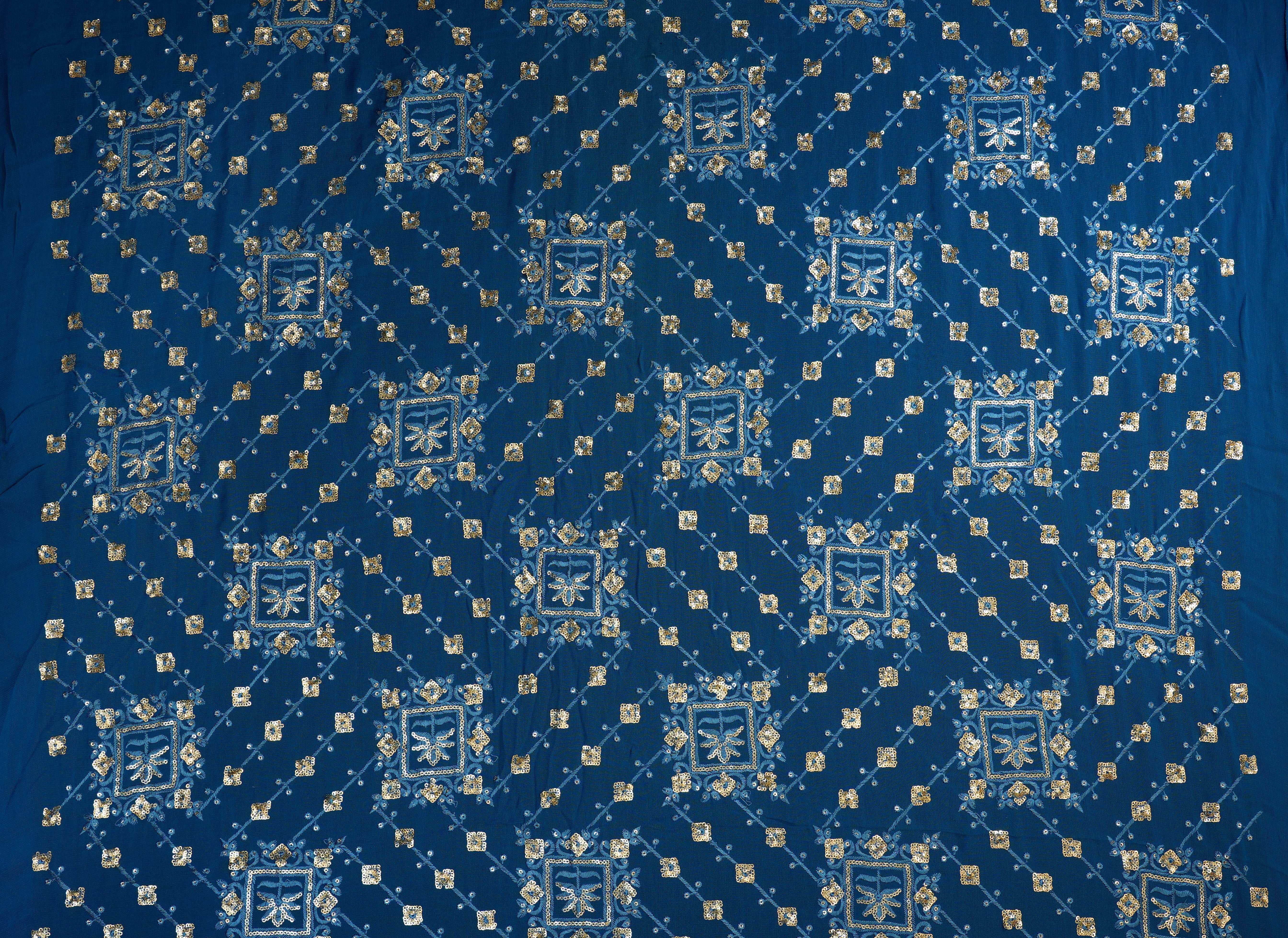 Blue georgette fabric with thread with golden sequins creating geometric allover pattern