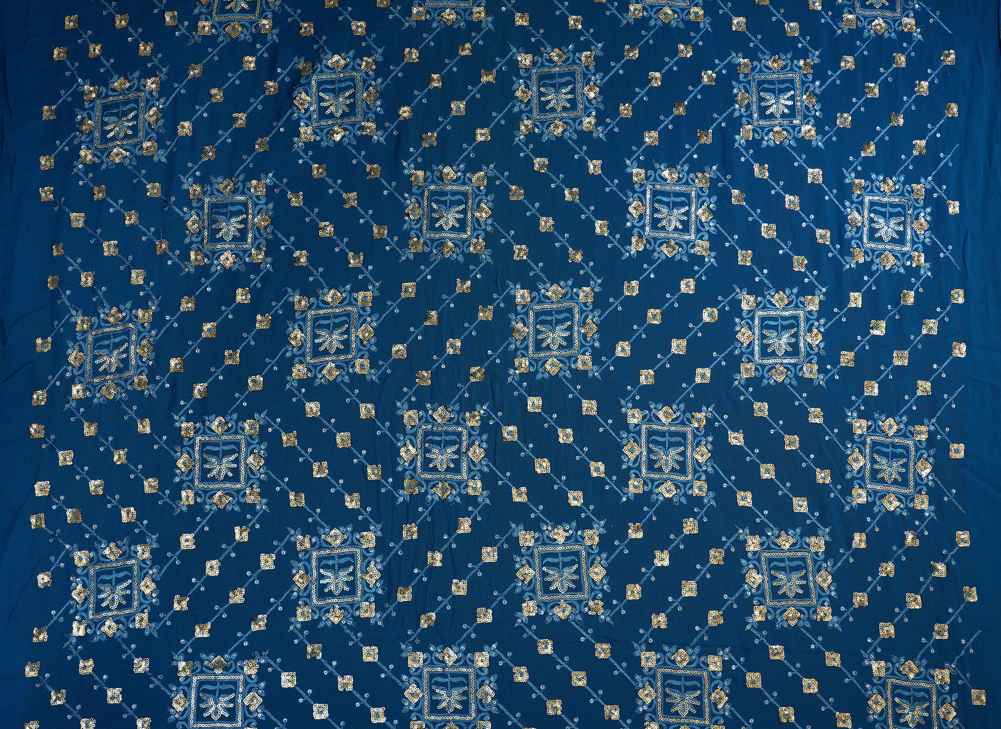 Blue georgette fabric with thread with golden sequins creating geometric allover pattern