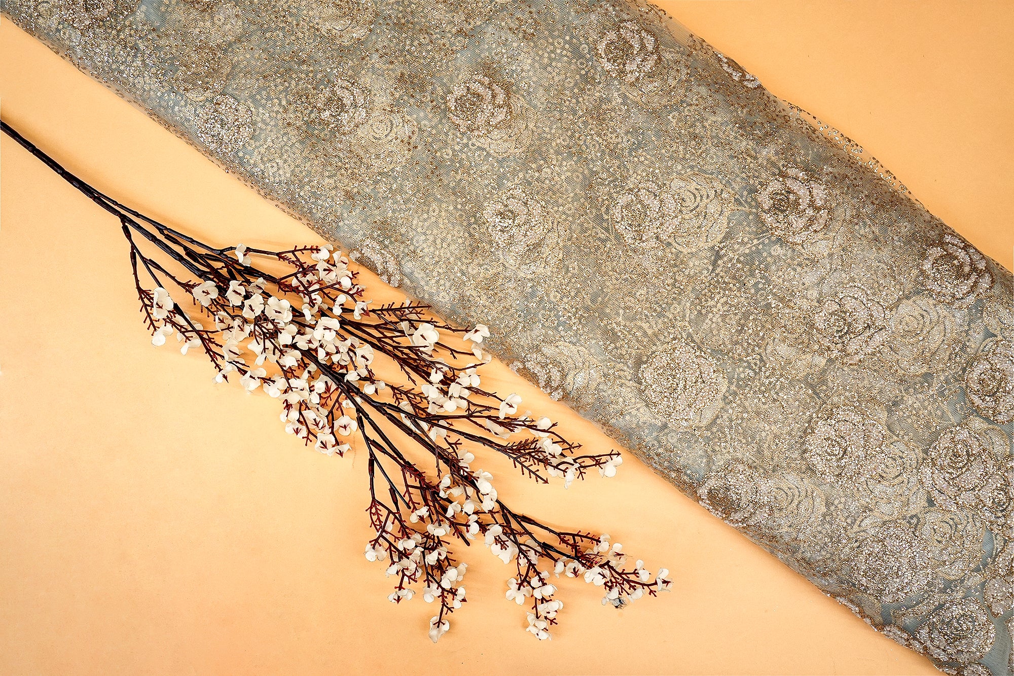 Light grey net with glitter and beads work allover creating floral pattern .