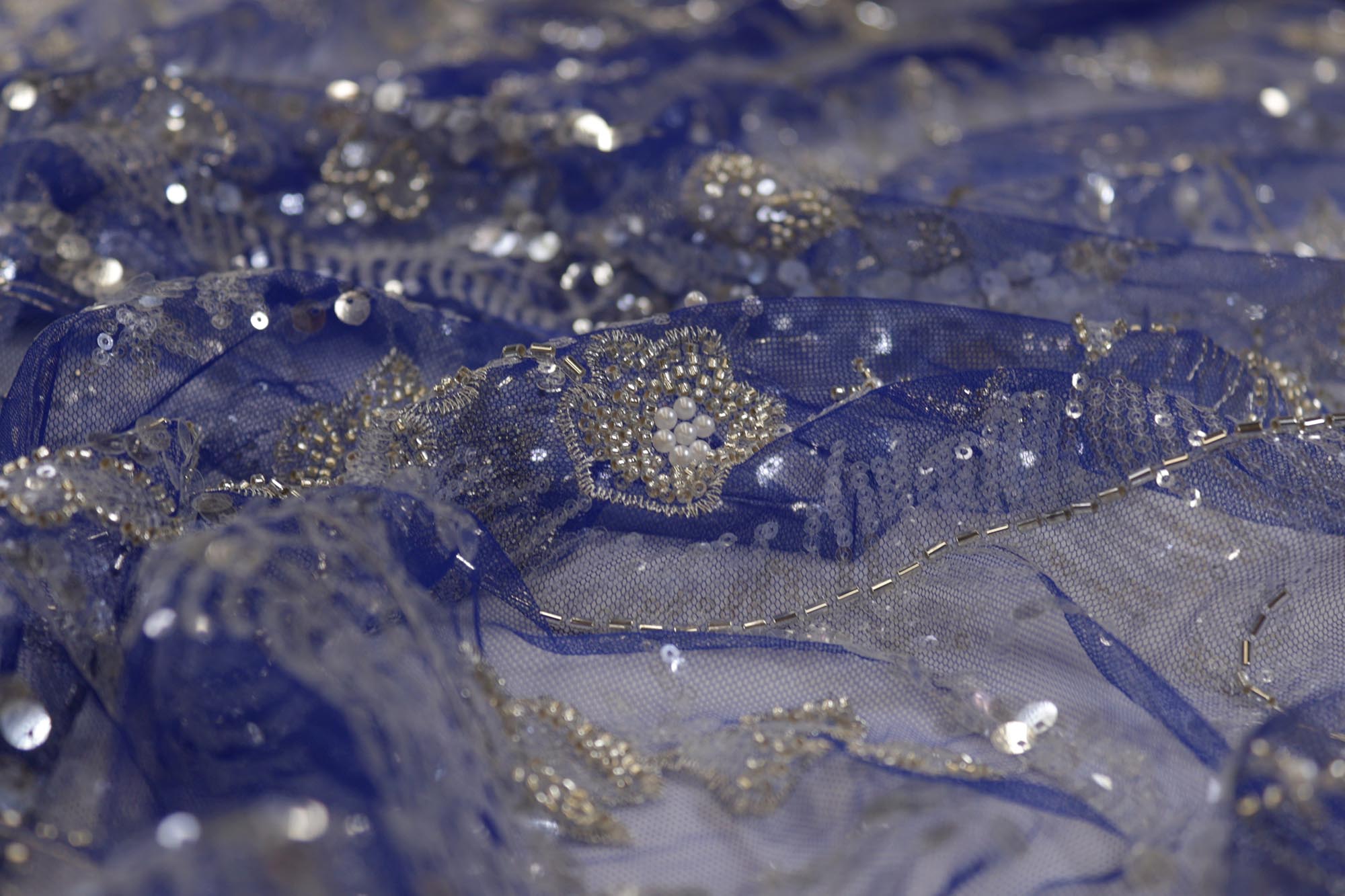 Blue net with water sequence ,zari, beads and pearls creating very intricate floral allover pattern