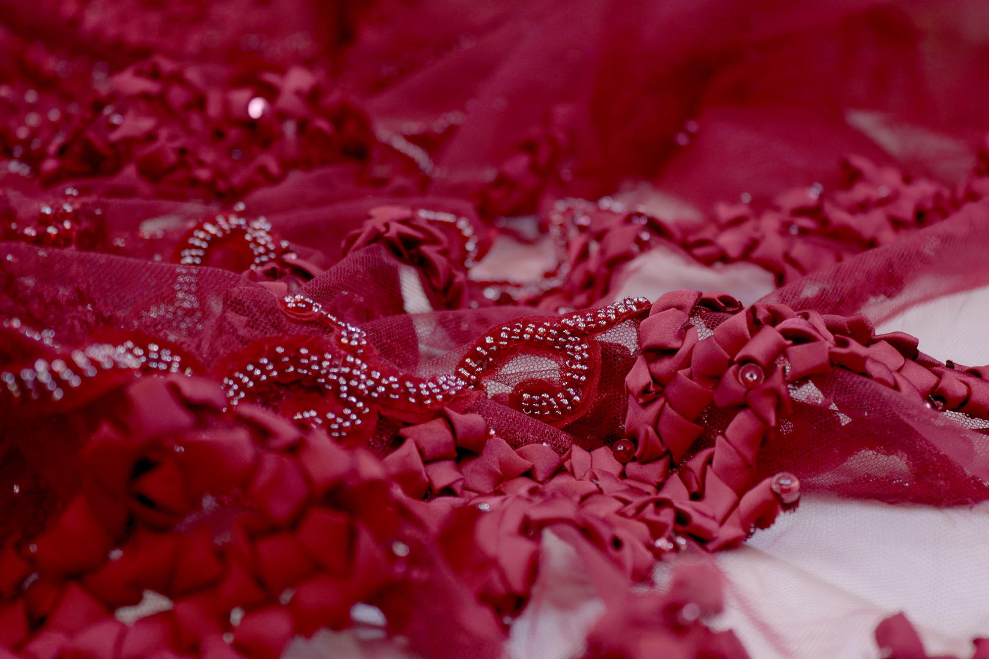 Maroon net with ribbon work with pearl, beads , thread and sequence work creating abstract pattern