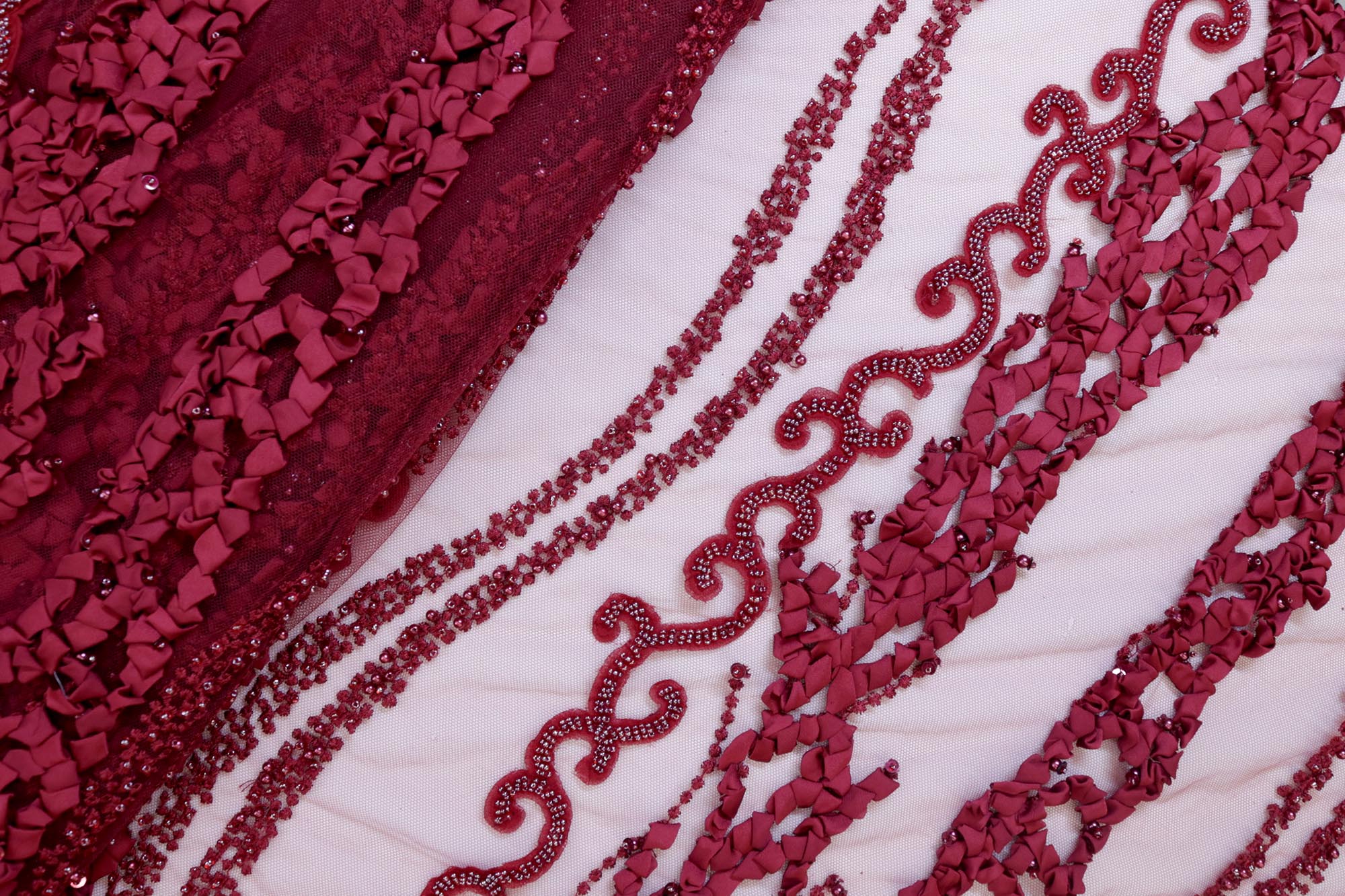 Maroon net with ribbon work with pearl, beads , thread and sequence work creating abstract pattern