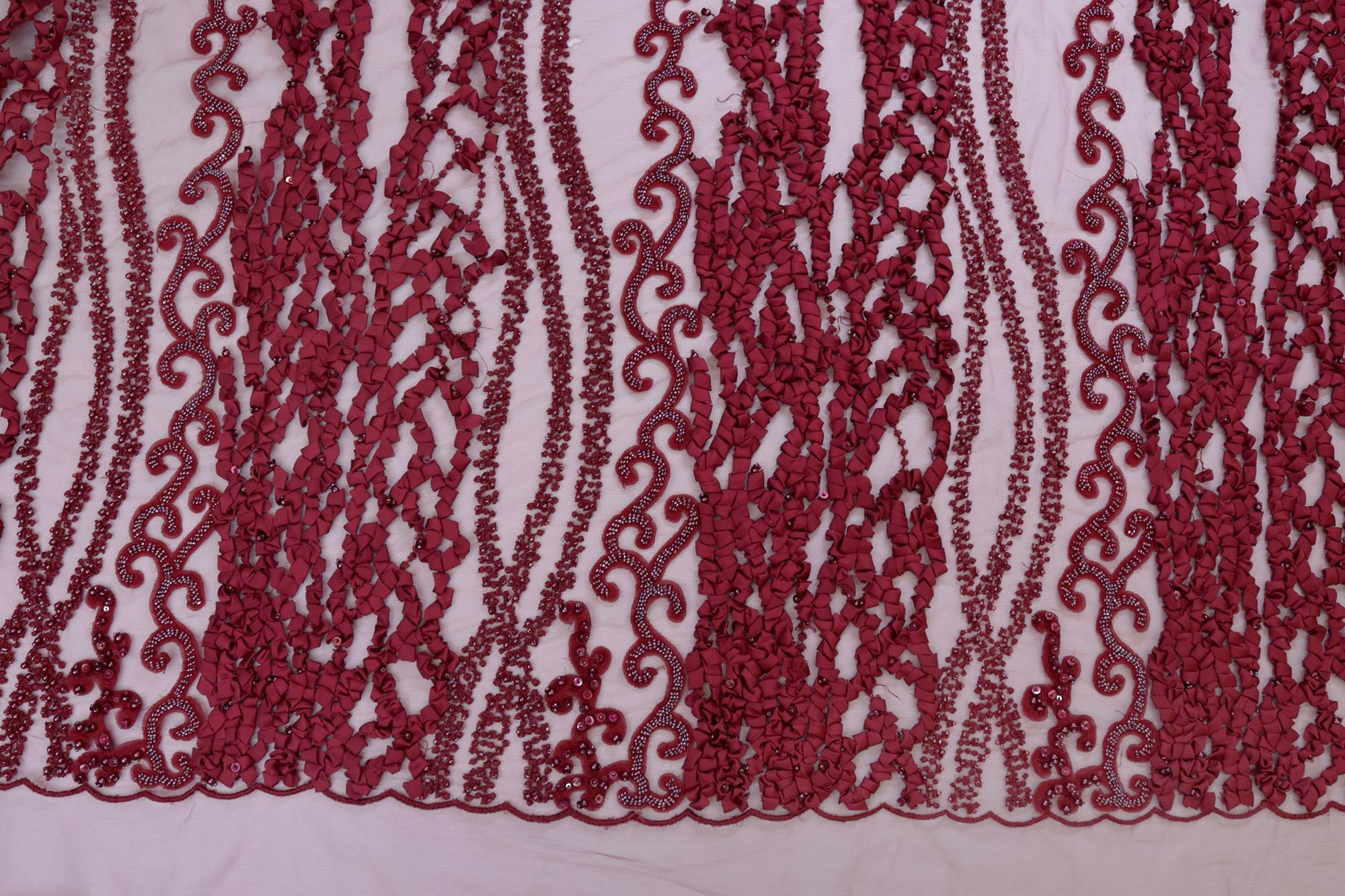 Maroon net with ribbon work with pearl, beads , thread and sequence work creating abstract pattern